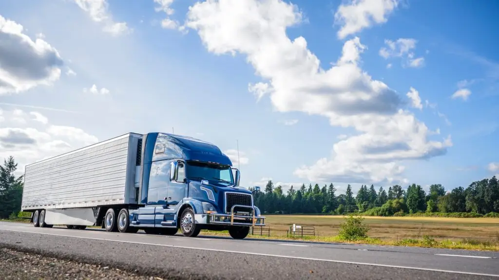 Blue semi-truck hauling a trailer on a highway, representing logistics, freight transportation, and supply chain distribution.